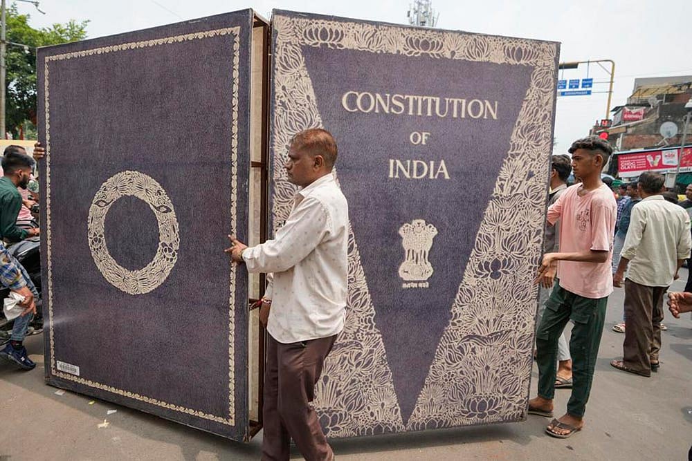 Photo: AP/Ajit Solanki : Dalits carry a huge replica of the Indian constitution during a nationwide strike against the Supreme Court's decision on affirmative action for people in the lowest castes in Ahmedabad.