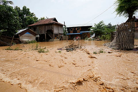 Myanmar floods: Debris from half-submerged residences float on a road