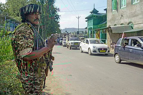 J&K Assembly Polls: A security personnel stands guard during a roadshow of MP and Awami Ittehad Party chief Sheikh Abdul Rashid