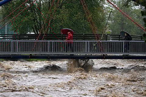 European Floods 2024: Residents cross a bridge during floods in Chechia
