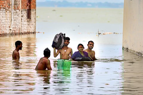 People shift their belongings to a safer place after a rise in the water level of Rivers Ganga and Yamuna