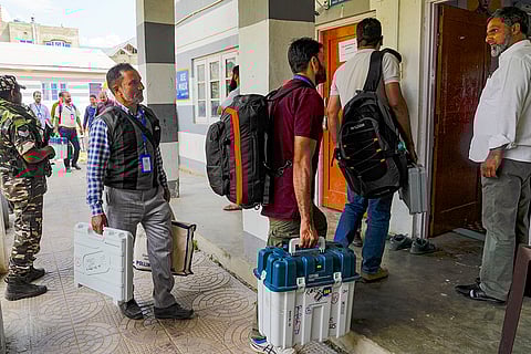 J&K Polls 2024, South Kashmir: Election Staff carrying EVMs arrive at a polling station