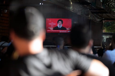 People watch the speech of Hezbollah leader Hassan Nasrallah as they sit in a cafe in the southern suburbs of Beirut, Thursday`