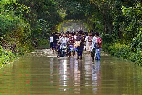 Bengal floods: People travel through a flooded area in Howrah