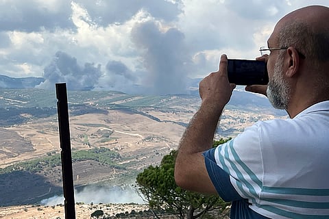 Lebanon Mideast Tensions: A man uses his phone to document Israeli shelling