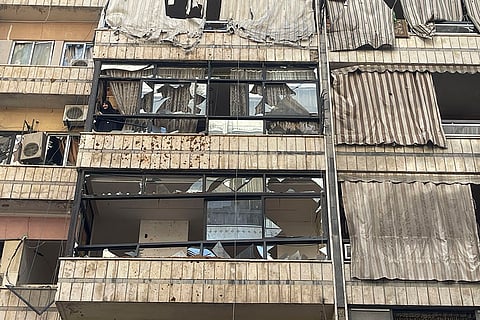 Lebanon Mideast Tensions: A woman checks the scene of a missile strike from her damaged house