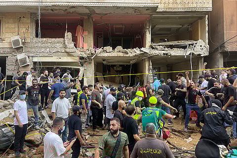 Lebanon Mideast Tensions: People gather near a damaged building in Beirut