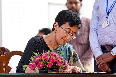 Atishi signs documents after taking oath as Delhi CM