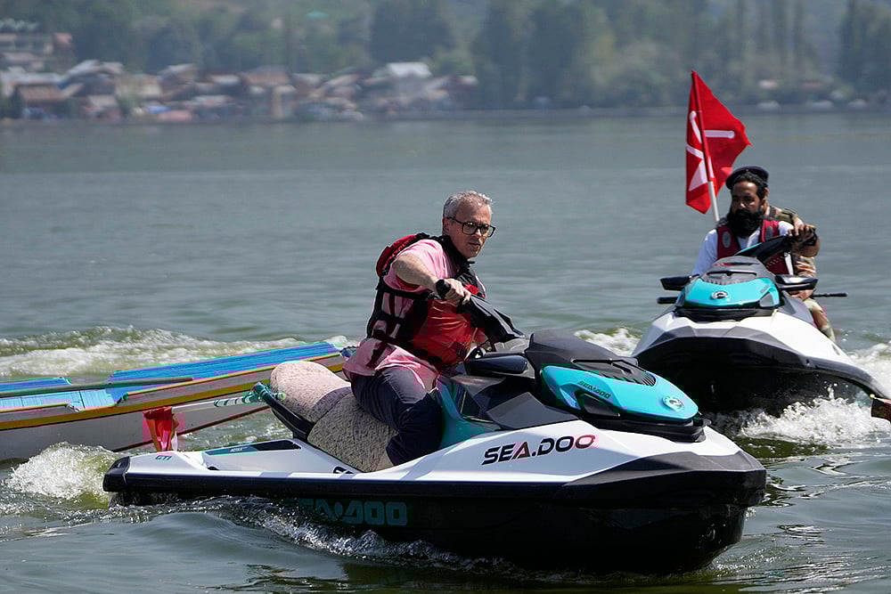 | Photo: AP/Mukhtar Khan : JKNC leader Omar Abdullah, rides a jet ski during an election rally at Dal Lake