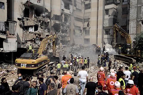 Emergency workers use excavators to clear the rubble at the site of Friday's Israeli strike in Beirut's southern suburbs, Saturday, Sept. 21, 2024.