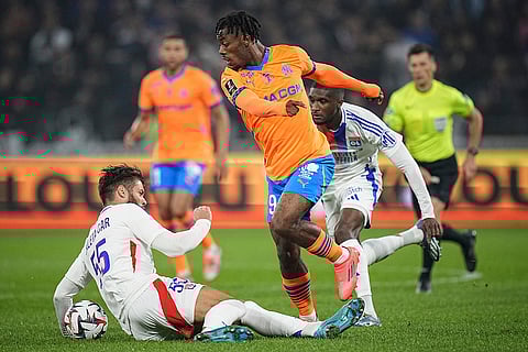 Ligue 1 Soccer, Marseille vs Lyon: Marseille's Elye Wahi, center, challenges  Lyon's Duje Caleta-Car, left, for the ball