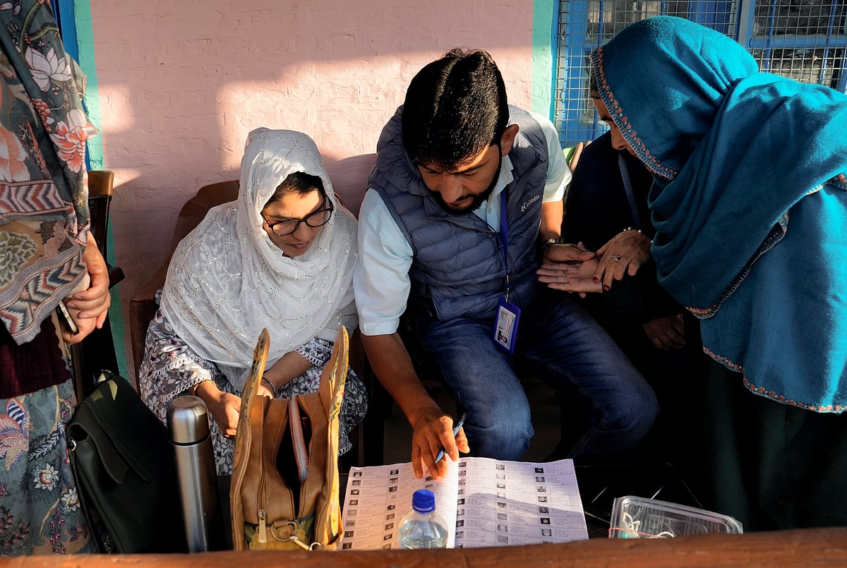 PTI

 : Pulwama: An elderly voter gets her credentials checked by a Booth Level Officer