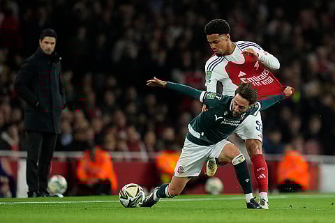 EFL Cup, Arsenal vs Bolton Wanderers: Bolton's Josh Sheehan, left, fights for a ball with Arsenal's Ethan Nwaneri