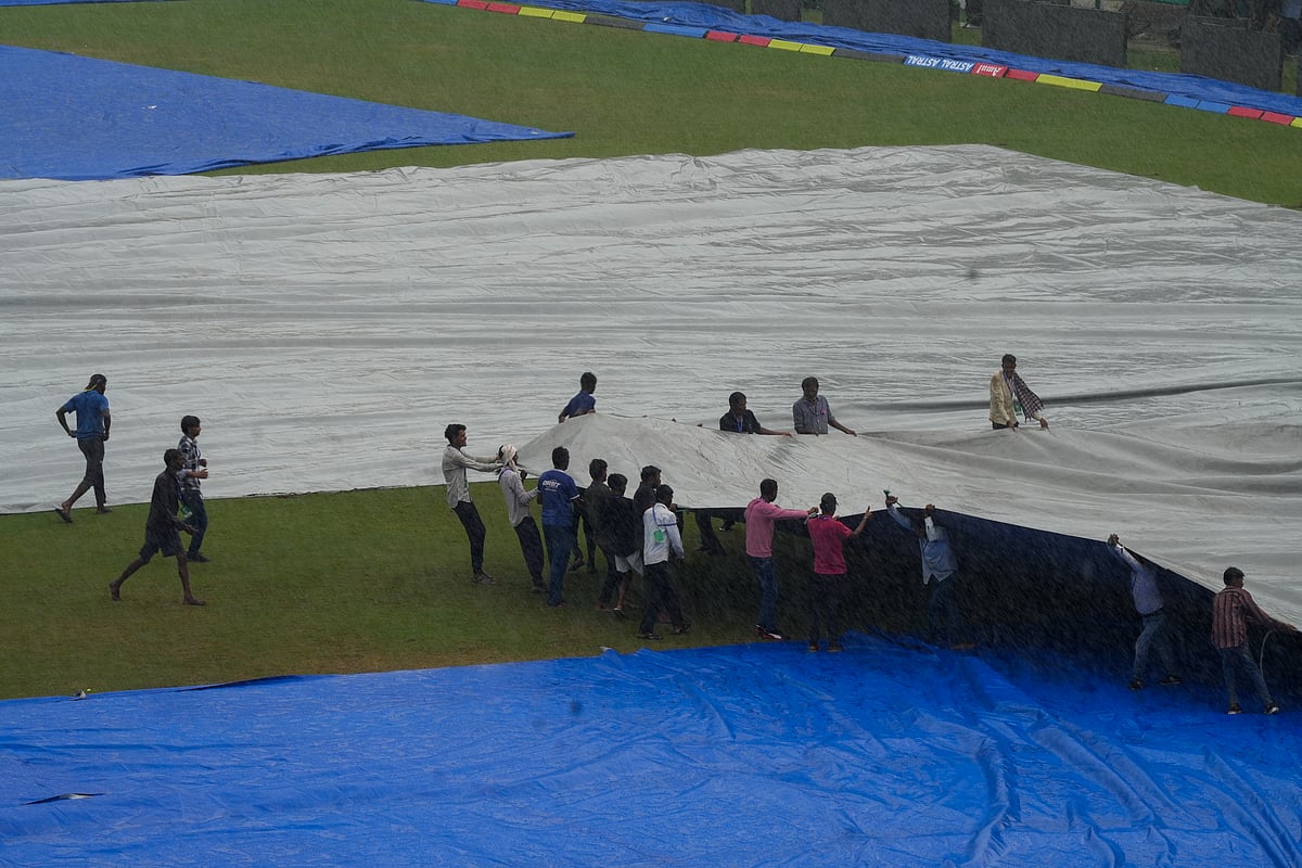 Ground staff cover the ground during rains ahead of the 2nd test match between India and Bangladesh at the Green Park stadium, Kanpur, Sept. 26, 2024. - PTI/Vijay Verma