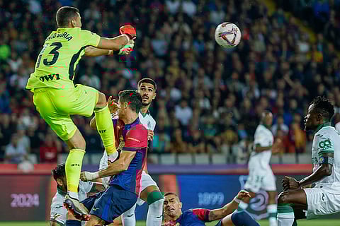 La Liga 2024-25, Barcelona vs Getafe: Getafe's goalkeeper David Soria, top, makes a save in front of Barcelona's Robert Lewandowski