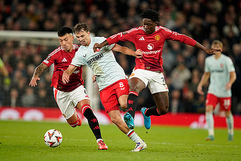 UEFA Europa League, Manchester United vs Twente: Manchester United's Lisandro Martinez, left, and Kobbie Mainoo, right, challenge for the ball with Twente's Youri Regeer