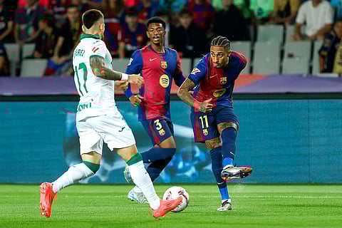 La Liga 2024-25, Barcelona vs Getafe: Getafe's Carles Perez, left, tries to block a shot from Barcelona's Raphinha
