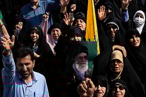 Israel-Hezbollah War: Iranian worshippers chant slogans as one holds a poster of Supreme leader Ayatollah Ali Khamenei during a demonstration