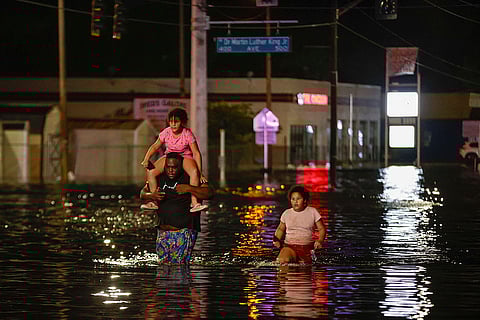 Hurricane Helene: Jamir Lewis wades through floodwaters with his two daughters