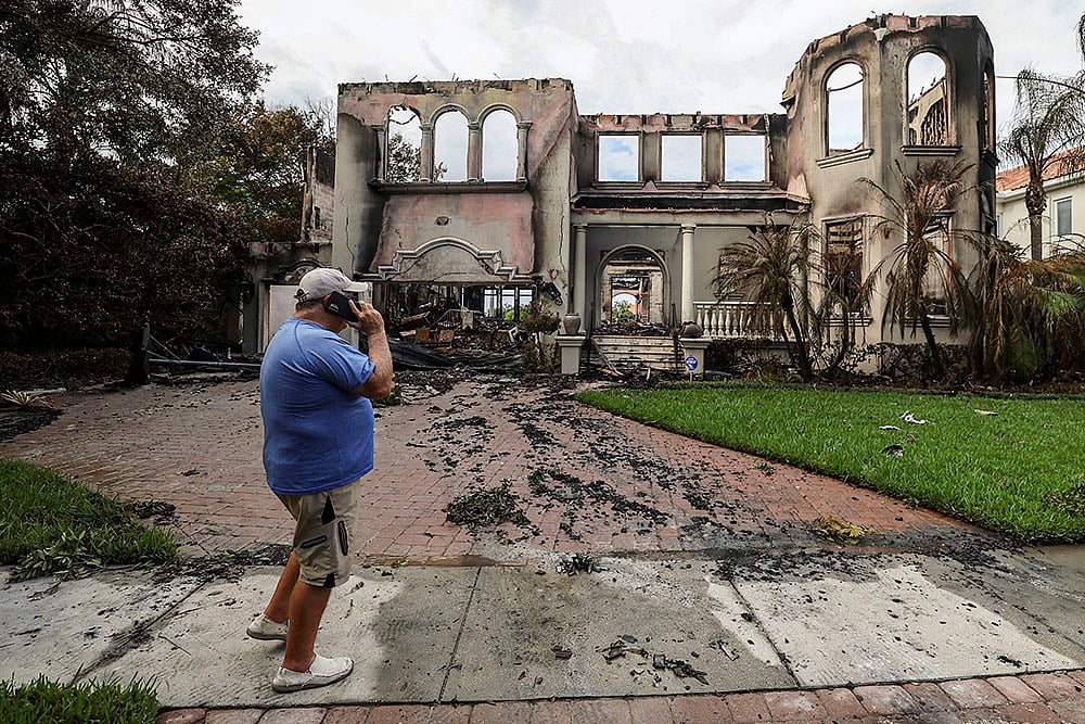| Photo: AP/Mike Carlson : Hurricane Helene: Joe Daum looks at the remains of a friend's home 