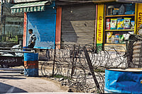 Kashmir's Graffiti From The Past | Photo Story Photo: Yasir Iqbal : Sights of Silence: A man standing next to a checkpoint in downtown Srinagar