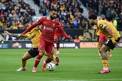 English Premier League 2024-25, Wanderers vs Liverpool: Liverpool's Mohamed Salah, center, is challenged by Wolverhampton Wanderers' Joao Gomes