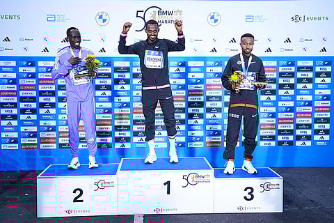 Berlin Marathon: Second placed Cybrian Kotut, winner Milkesa Mengesha and third placed Haymanot Alew attend the medal ceremony