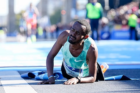 Berlin Marathon: Milkesa Mengesha from Ethiopia lays on the ground and reacts after he crosses the finish line