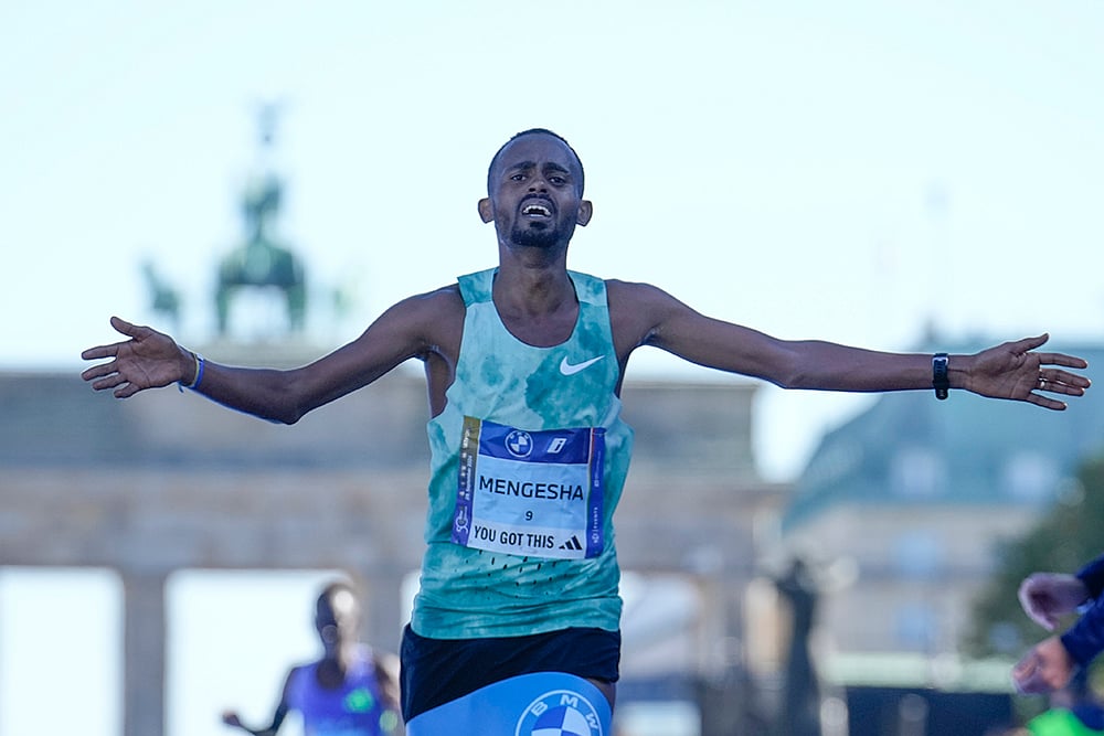 | Photo: AP/Ebrahim Noroozi : Berlin Marathon: Milkesa Mengesha from Ethiopia celebrates as he crosses the finish line