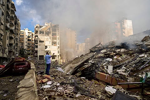 Mideast Tensions: A man documents the damaged buildings in Beirut's southern suburb