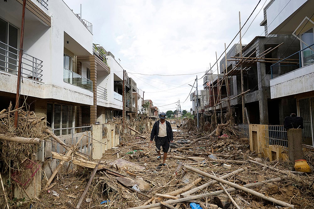 | Photo: AP/Gopen Rai : Nepal Floods: A man walks on a street strewn with debris