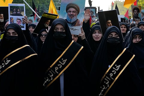 Mideast Tensions: Demonstrators hold pictures of Hassan Nasrallah during a rally commemorating slain Hezbollah leader