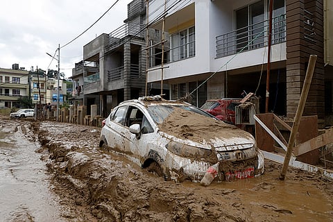 Nepal Floods: A car parked outside a building is swamped in mud in Kathmandu