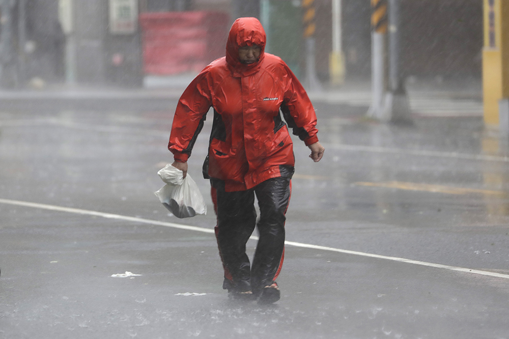 Taiwan Typhoon Krathon: A woman struggles in the wind and rain
