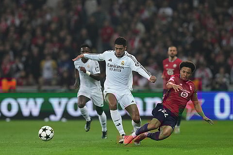 UCL 2024-25, Lille vs Real Madrid: Real Madrid's Jude Bellingham, center, and Lille's Tiago Santos fight for the ball