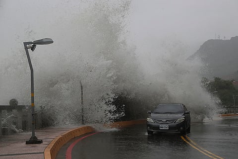 Taiwan Typhoon Krathon: A car moves along the shore in Kaohsiung