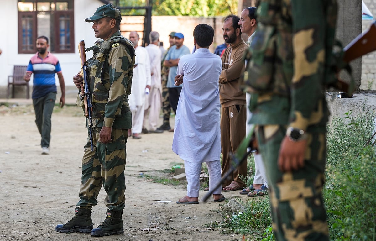 PTI : Security personnel stand guard as voters wait to cast their votes during the third and final phase of J&K Assembly elections, at Handwara in Kupwara district of North Kashmir, Tuesday, Oct 1, 2024