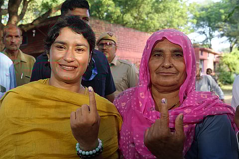 Haryana Assembly elections: Congress candidate from Julana constituency Vinesh Phogat and her family member show their fingers marked with indelible ink after casting their votes