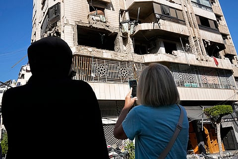 Mideast Tensions: Lebanese women stand in front an apartment in a multistory building hit by Israeli airstrike