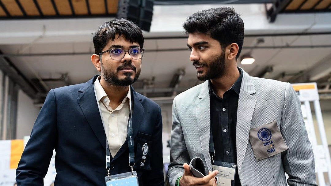 File photo of Indian open team captain Srinath Narayanan (left) talking to D Gukesh after a game at the Chess Olympiad in Budapest. - FIDE/Maria Emelianova