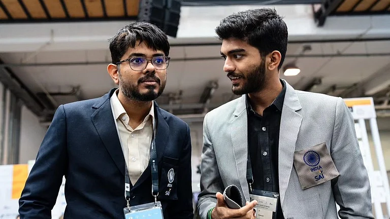File photo of Indian open team captain Srinath Narayanan (left) talking to D Gukesh after a game at the Chess Olympiad in Budapest. - FIDE/Maria Emelianova