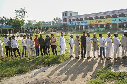 Haryana Assembly elections: Voters wait in a queue to cast their votes at a polling station at Ghasera village