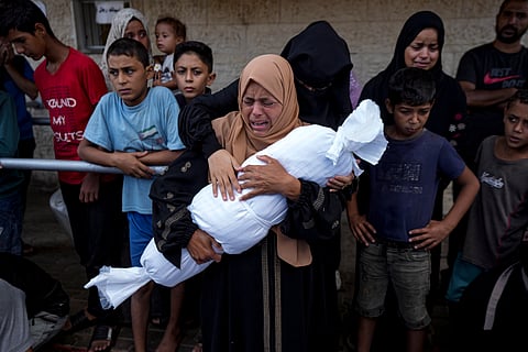 Palestinians mourn relatives killed in the Israeli bombardment of the Gaza Strip, at a hospital in Deir al-Balah, Tuesday, Oct. 1, 2024