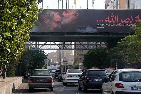 Vehicles drive past a billboard showing the late Iranian Revolutionary Guard Gen. Qassem Soleimani, who was killed in Iraq in a U.S. drone attack in 2020, kissing forehead of slain Hezbollah leader Hassan Nasrallah, in Tehran, Iran, Saturday, Oct. 5, 2024.