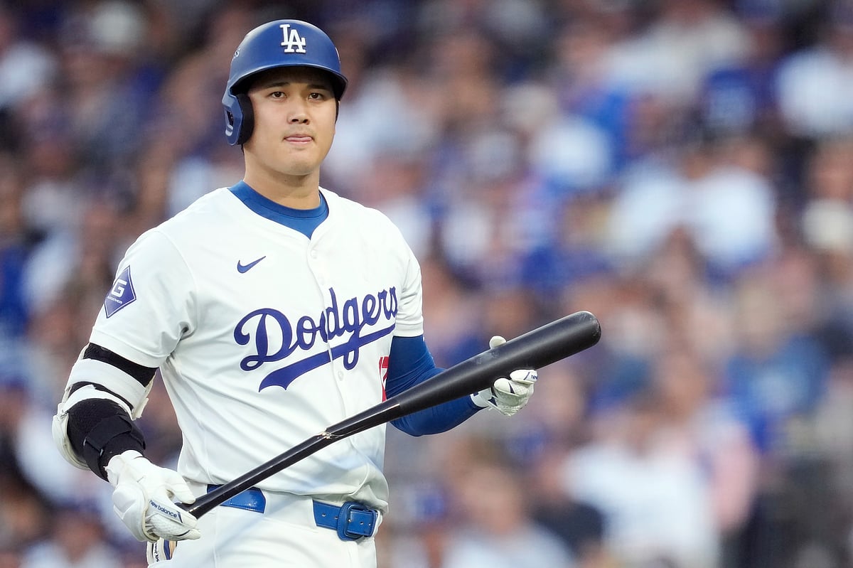 (AP Photo/Ashley Landis) : Los Angeles Dodgers' Shohei Ohtani walks back to replace his bat after breaking it on a foul ball during the third inning in Game 2 of a baseball NL Division Series against the San Diego Padres, Sunday, Oct. 6, 2024, in Los Angeles. 
