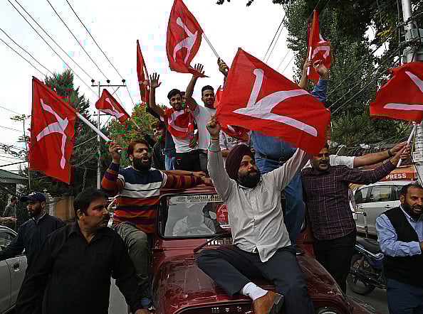 Waseem Andrabi/Hindustan Times via Getty Images : SRINAGAR, INDIA - OCTOBER 8: Supporters of National Conference (NC) celebrate outside the counting center on October 8, 2024 in Srinagar, India. National Conference Congress alliance has achieved victory in the Assembly polls, winning a total of 48 seats. The BJP won 29 seats.
