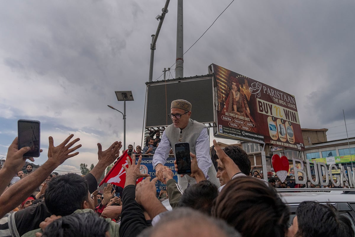 Jammu and Kashmir National Conference (JKNC) party leader Omar Abdullah, standing on car shakes hands with supporters as he celebrates his victory in the election for a local government in Indian controlled Kashmir, Budgam, Tuesday, Oct. 8, 2024.  - AP Photo/Dar Yasin