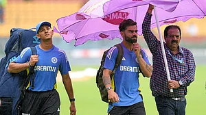 AP/Aijaz Rahi : India's Virat Kohli, center, and Yashasvi Jaiswal, left, walk across the field after rains delayed the start of the day one of the first cricket test match between India and New Zealand at the M.Chinnaswamy Stadium.