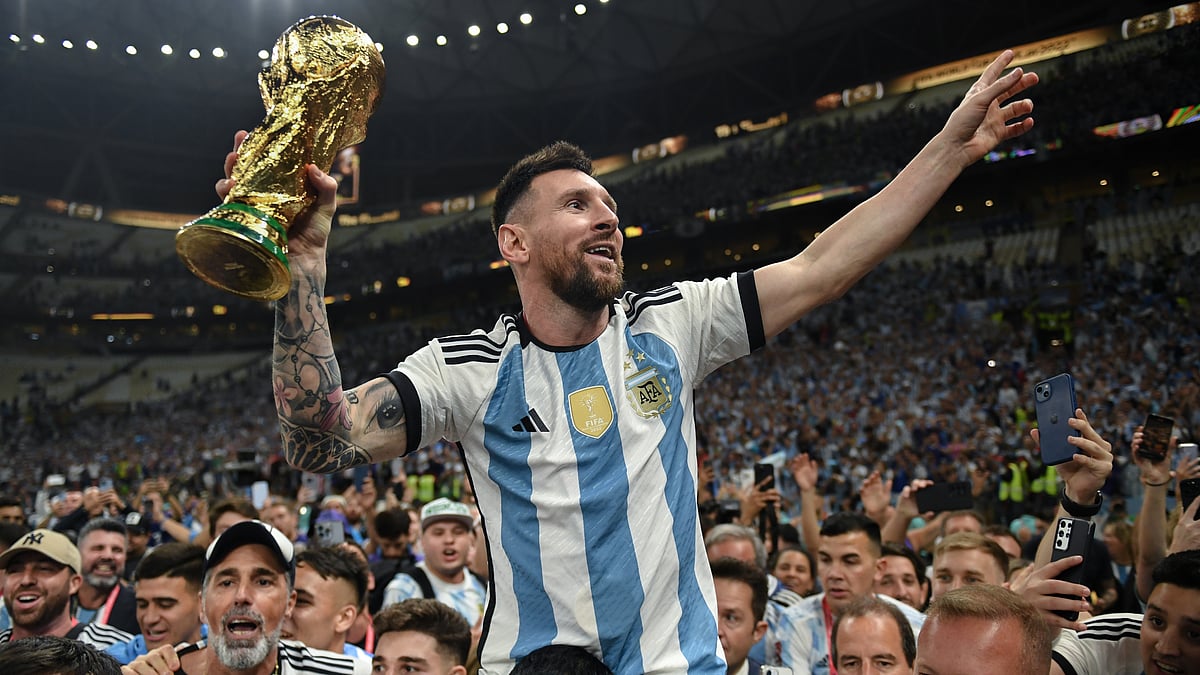 Lionel Messi hoists the World Cup trophy aloft - AP