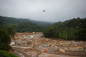 Abhishek Chinnappa/Getty Images : Rescue personnel look for survivors through debris at the site of the landslide on July 31, 2024 in Mundakkai village, Kerala.